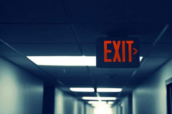 An exit sign in a hallway, pointing right.
