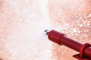 Horizontal fire sprinkler at the end of exposed fire sprinkler system piping.