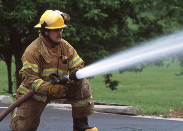 Un bombero usando una manguera de ataque.