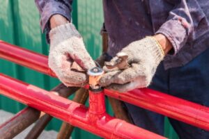 A sprinkler contractor installing a fire sprinkler