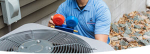 Uno de nuestros técnicos de mantenimiento revisando los niveles de refrigerante en una unidad HVAC exterior.